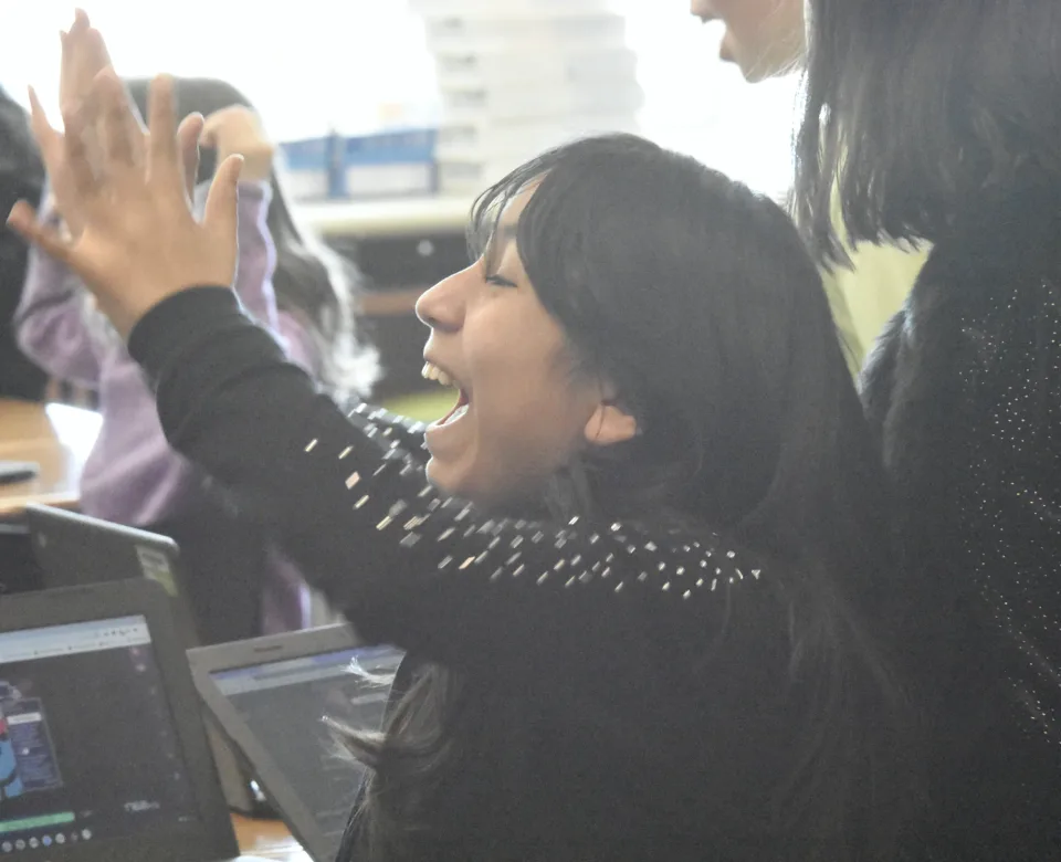 A student laughs mid high five.