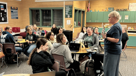 A group of elementary teachers work together collaboratively during a faculty meeting while running a team-building mission.
