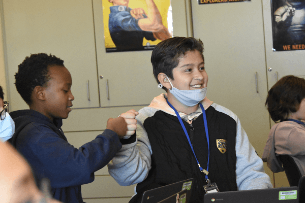 Students fist bump during mission