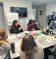 Group of Mission.io employees working around a table on goals and objectives for future development.