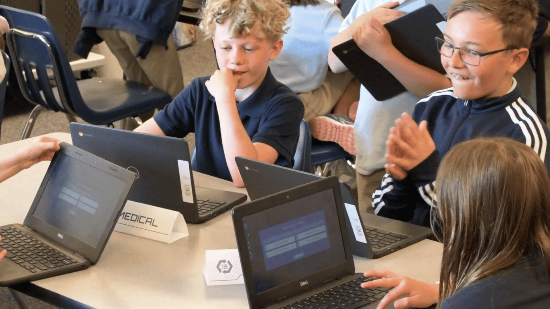 Elementary students collaborating on laptops during a classroom mission activity, using critical thinking and teamwork to solve real-world problems in an engaging learning environment.